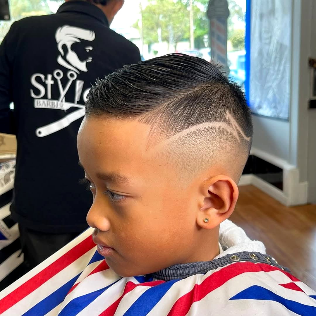 Young client mid-cut in a STYLO Barbershop cape