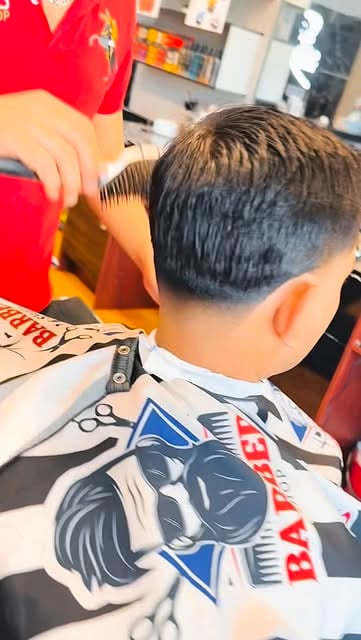 Fresh cut finished in a striped barber cape